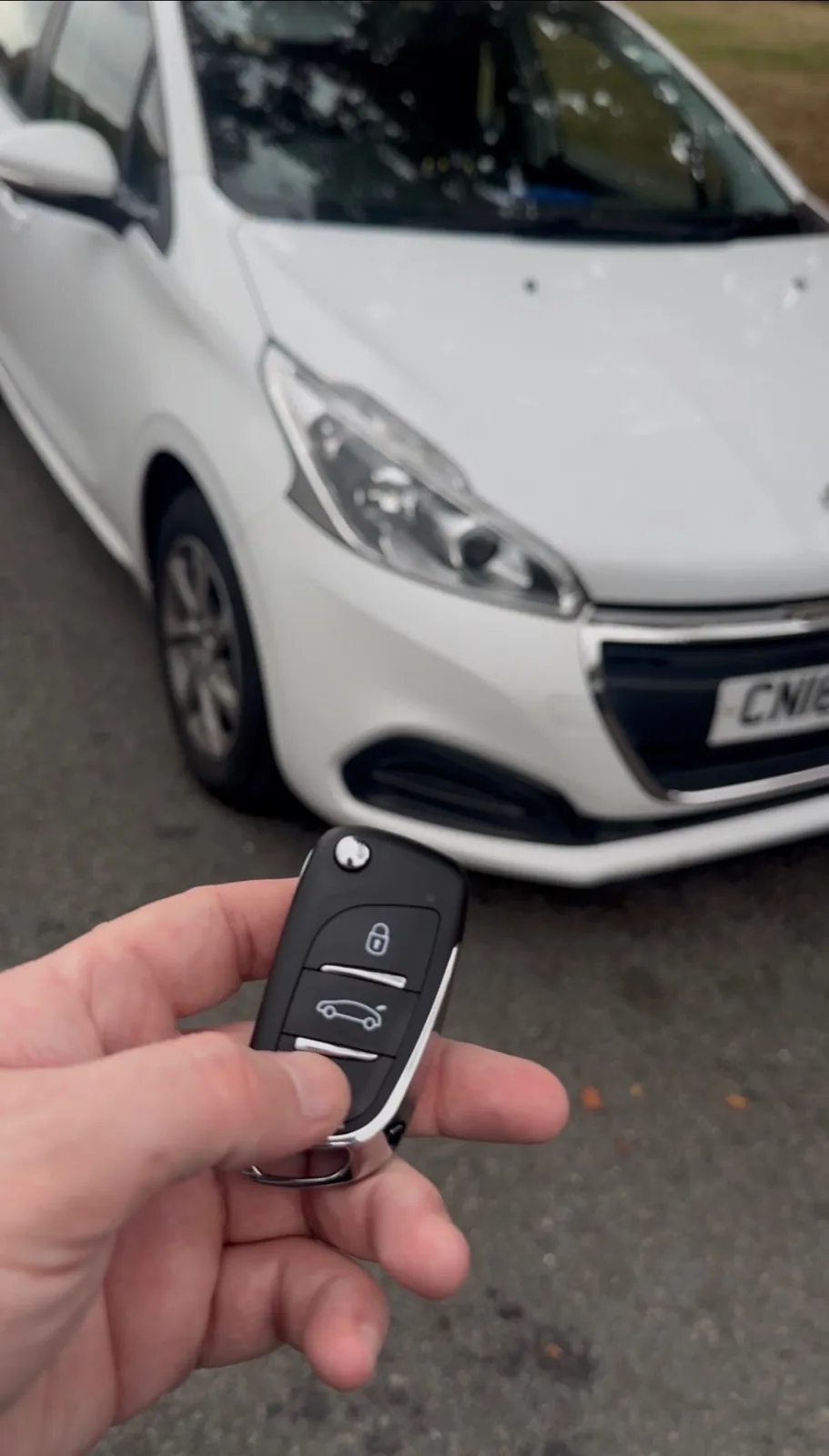 Peugeot 208 flip key programmed and held in front of the vehicle in Derby