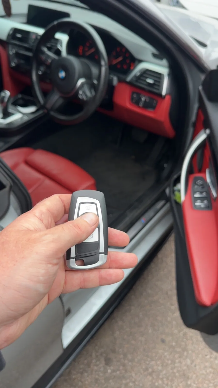 BMW smart key held inside a BMW with red leather interior in Derby