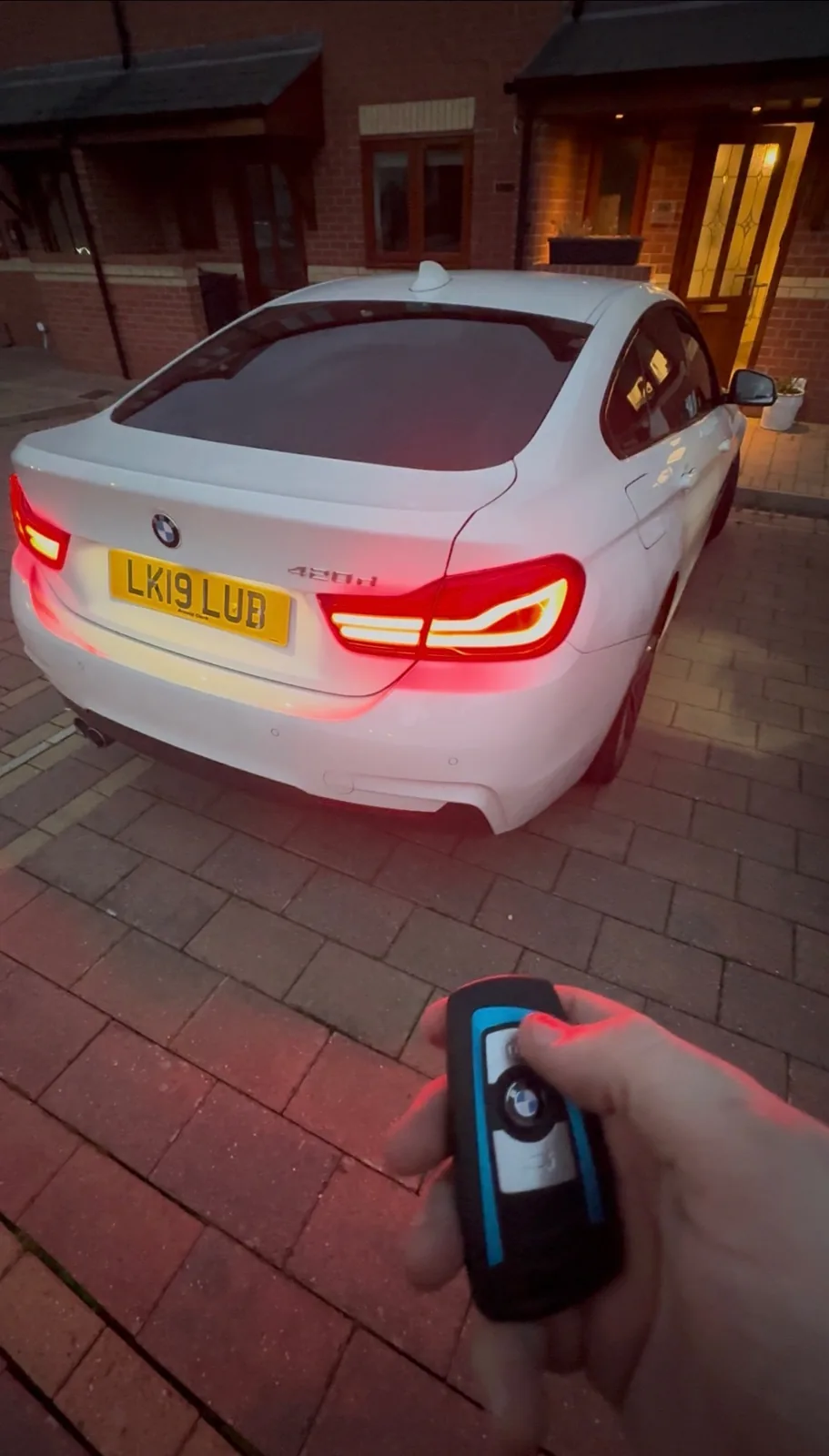 BMW key held behind a white BMW X-series in Derby after all-keys-lost programming