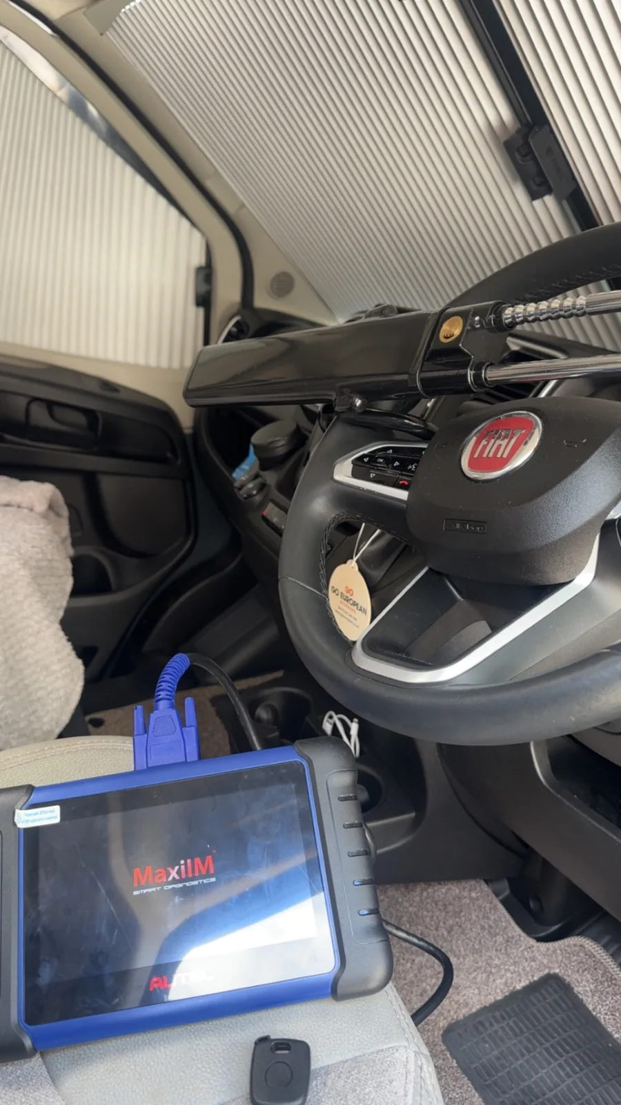 Fiat key being programmed with Autel diagnostic tablet at the steering column