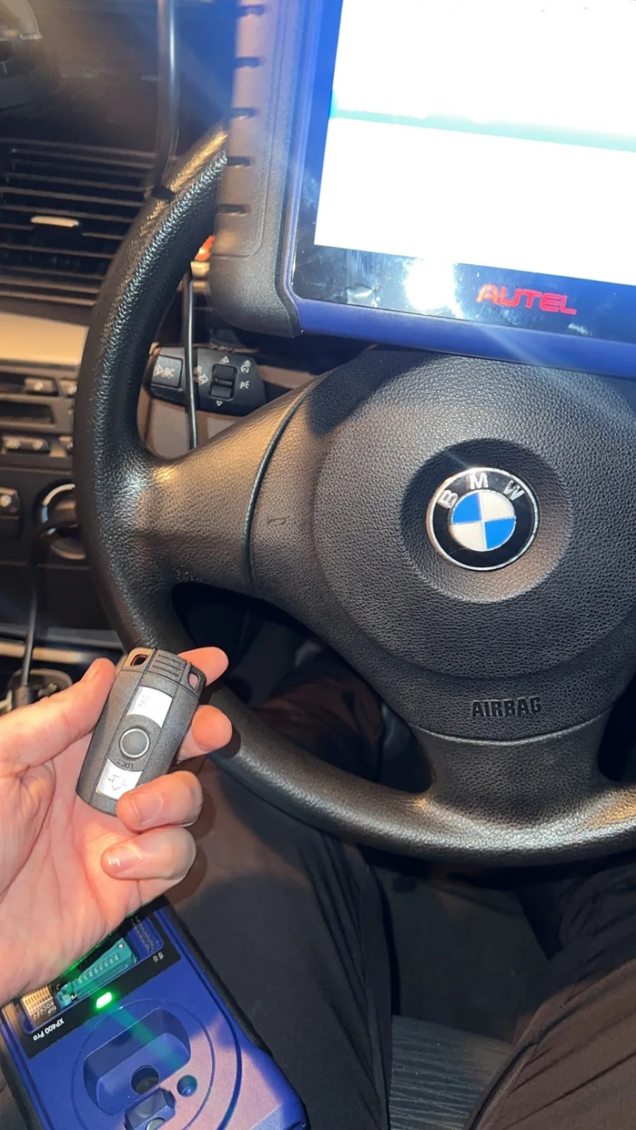 BMW remote key held at the steering wheel during on-site programming in Derby