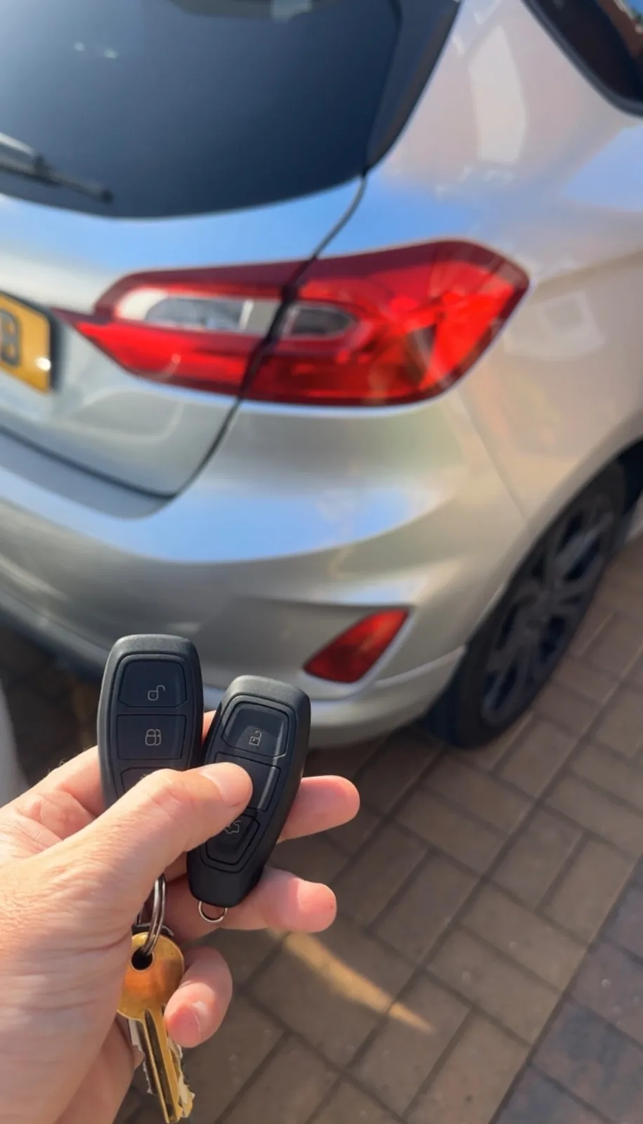 Ford Fiesta key held beside a silver Ford Fiesta in Derby