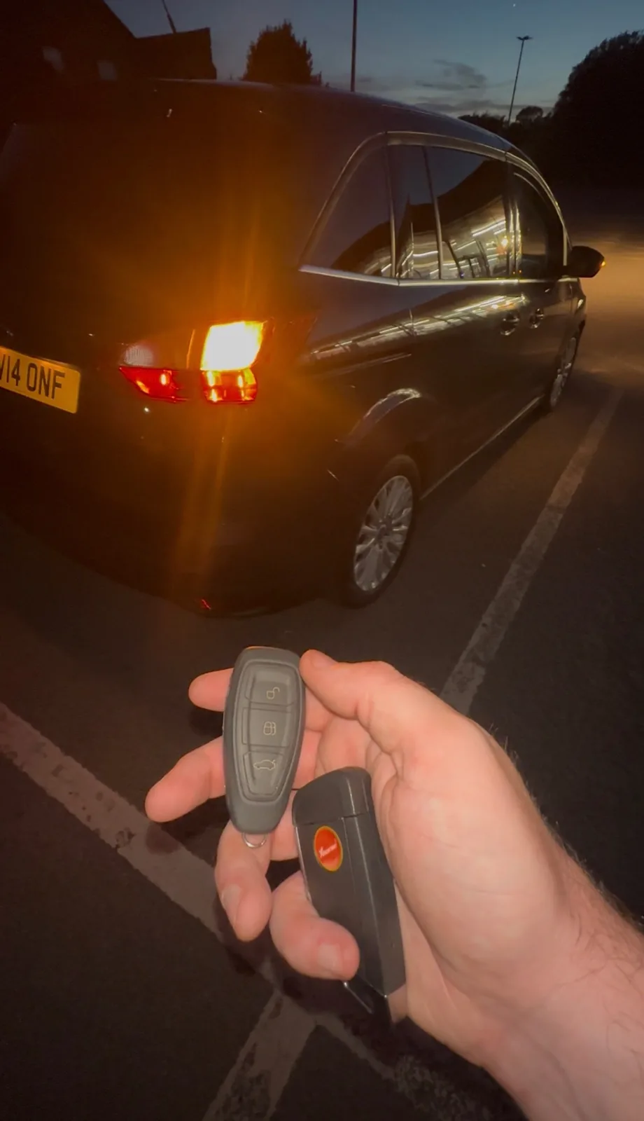 Freshly programmed remote key firing the hazard lights of a dark car at night